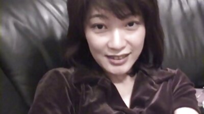 Една секси и екзотична азиатска жена лежи по гръб на секс и порно клипове леглото, гърбена